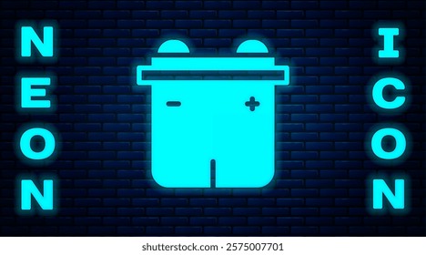 Glowing neon Car battery icon isolated on brick wall background. Accumulator battery energy power and electricity accumulator battery.  Vector