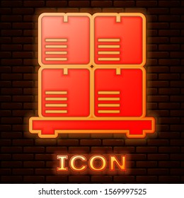 Glowing neon Cardboard boxes on pallet icon isolated on brick wall background. Closed carton delivery packaging box with fragile signs.  Vector Illustration