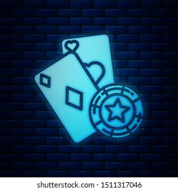 Glowing neon Casino chip and playing cards icon isolated on brick wall background. Casino poker.  Vector Illustration