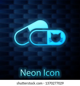 Glowing neon Cat and pills icon isolated on brick wall background. Prescription medicine for animal. Vector Illustration