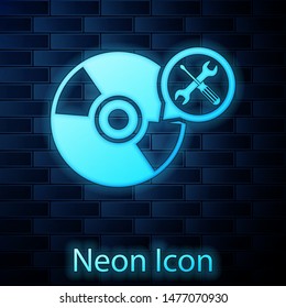 Glowing neon CD or DVD disk with screwdriver and wrench icon isolated on brick wall background. Adjusting, service, setting, maintenance, repair, fixing.  Vector Illustration