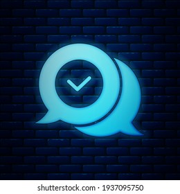 Glowing neon Check mark in speech bubble icon isolated on brick wall background. Security, safety, protection, privacy concept. Tick mark approved.  Vector