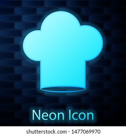 Glowing neon Chef hat icon isolated on brick wall background. Cooking symbol. Cooks hat.  Vector Illustration