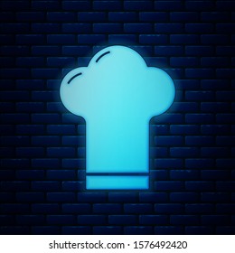 Glowing neon Chef hat icon isolated on brick wall background. Cooking symbol. Cooks hat.  Vector Illustration