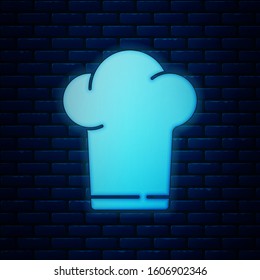 Glowing neon Chef hat icon isolated on brick wall background. Cooking symbol. Cooks hat.  Vector Illustration