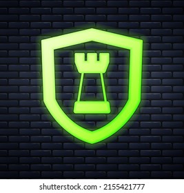 Glowing neon Chess shield icon isolated on brick wall background. Business strategy. Game, management, finance.  Vector