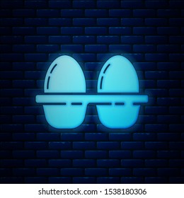 Glowing neon Chicken egg in box icon isolated on brick wall background.  Vector Illustration