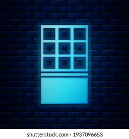 Glowing neon Chocolate bar icon isolated on brick wall background.  Vector