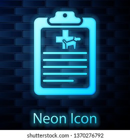 Glowing neon Clipboard with medical clinical record pet icon isolated on brick wall background. Health insurance form. Medical check marks report. Vector Illustration