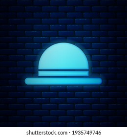 Glowing neon Clown hat icon isolated on brick wall background. Bowler hat.  Vector