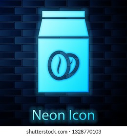 Glowing neon Coffee beans in bag icon isolated on brick wall background. Vector Illustration