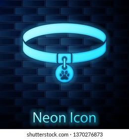 Glowing neon Collar with name tag icon isolated on brick wall background. Supplies for domestic animal. Dog or cat paw print. Cat and dog care. Pet chains. Vector Illustration