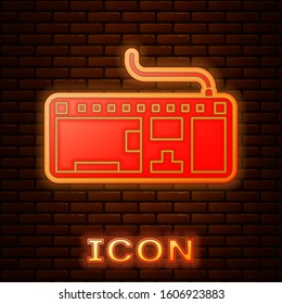 Glowing neon Computer keyboard icon isolated on brick wall background. PC component sign.  Vector Illustration