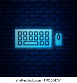 Glowing neon Computer keyboard and mouse icon isolated on brick wall background. PC component sign.  Vector Illustration