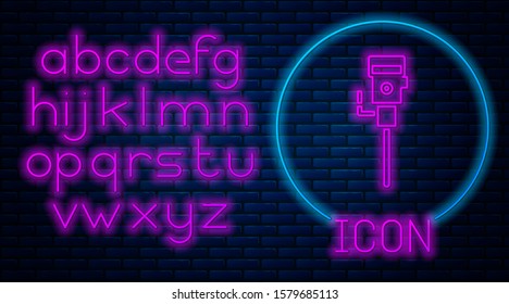 Glowing neon Construction jackhammer icon isolated on brick wall background. Neon light alphabet. Vector Illustration
