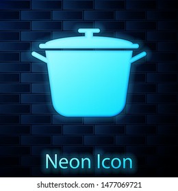 Glowing neon Cooking pot icon isolated on brick wall background. Boil or stew food symbol.  Vector Illustration