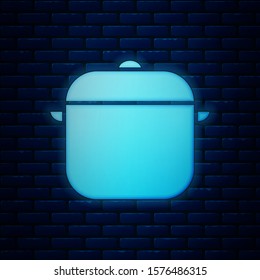 Glowing neon Cooking pot icon isolated on brick wall background. Boil or stew food symbol.  Vector Illustration