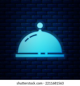 Glowing neon Covered with a tray of food icon isolated on brick wall background. Tray and lid. Restaurant cloche with lid. Kitchenware symbol.  Vector