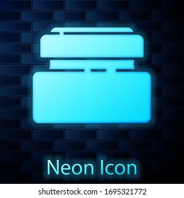 Glowing neon Cream or lotion cosmetic tube icon isolated on brick wall background. Body care products for men. Vector Illustration