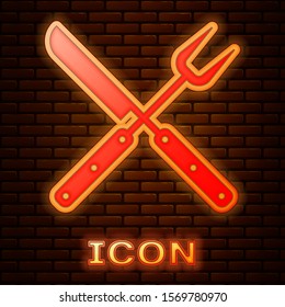 Glowing neon Crossed fork and knife icon isolated on brick wall background. BBQ fork and knife sign. Barbecue and grill tools.  Vector Illustration