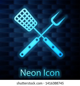 Glowing neon Crossed fork and spatula icon isolated on brick wall background. BBQ fork and spatula sign. Barbecue and grill tools. Vector Illustration