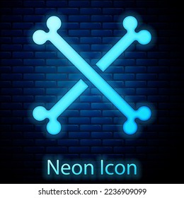 Glowing neon Crossed human bones icon isolated on brick wall background.  Vector