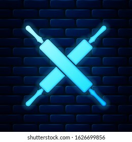 Glowing neon Crossed rolling pins icon isolated on brick wall background. Kitchen utensils and equipment.  Vector Illustration