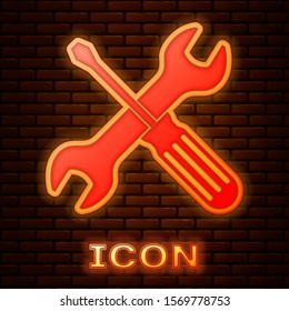 Glowing neon Crossed screwdriver and wrench tools icon isolated on brick wall background. Service tool symbol.  Vector Illustration