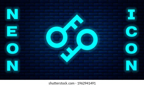 Glowing neon Cryptocurrency key icon isolated on brick wall background. Concept of cyber security or private key, digital key with technology interface.  Vector