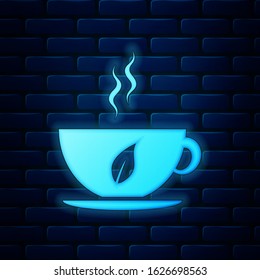 Glowing neon Cup of tea and leaf icon isolated on brick wall background.  Vector Illustration