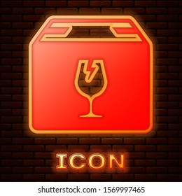 Glowing neon Delivery package box with fragile content symbol of broken glass icon isolated on brick wall background. Box, package, parcel sign.  Vector Illustration