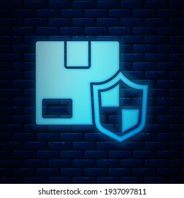 Glowing neon Delivery security with shield icon isolated on brick wall background. Delivery insurance. Insured cardboard boxes beyond the shield.  Vector