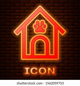 Glowing neon Dog house and paw print pet icon isolated on brick wall background. Dog kennel.  Vector Illustration