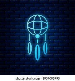 Glowing neon Dream catcher with feathers icon isolated on brick wall background.  Vector