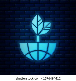 Glowing neon Earth globe and leaf icon isolated on brick wall background. World or Earth sign. Geometric shapes. Environmental concept.  Vector Illustration