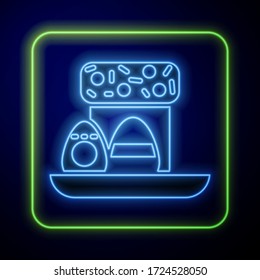 Glowing neon Easter cake and eggs icon isolated on blue background. Happy Easter.  Vector Illustration