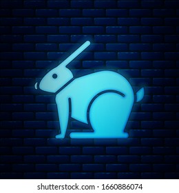 Glowing neon Easter rabbit icon isolated on brick wall background. Easter Bunny.  Vector Illustration
