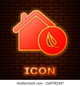 Glowing neon Eco friendly house icon isolated on brick wall background. Eco house with leaf.  Vector Illustration