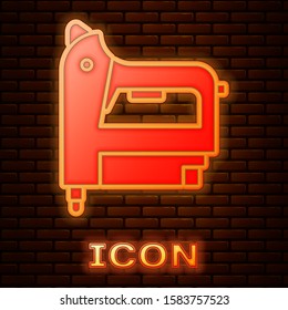 Glowing neon Electric construction stapler icon isolated on brick wall background. Working tool.  Vector Illustration