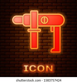 Glowing neon Electric drill machine icon isolated on brick wall background. Repair tool.  Vector Illustration