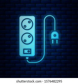 Glowing neon Electric extension cord icon isolated on brick wall background. Power plug socket.  Vector Illustration