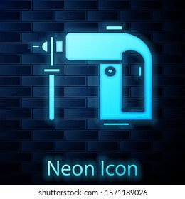 Glowing neon Electric rotary hammer drill machine icon isolated on brick wall background. Working tool for construction, finishing, repair work.  Vector Illustration