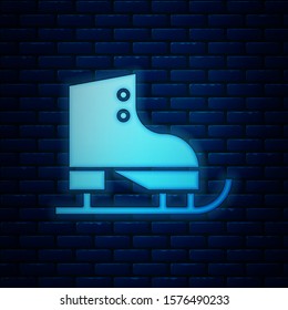 Glowing neon Figure skates icon isolated on brick wall background. Ice skate shoes icon. Sport boots with blades.  Vector Illustration