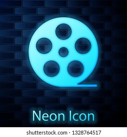 Glowing neon Film reel icon isolated on brick wall background. Vector Illustration