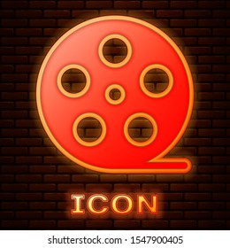 Glowing neon Film reel icon isolated on brick wall background.  Vector Illustration