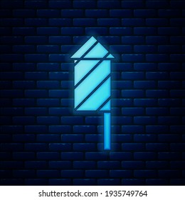 Icono del cohete Firework de neón brillante aislado en el fondo de la pared de ladrillo. Concepto de fiesta divertida. Símbolo pirotécnico explosivo.  Vector