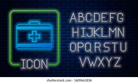 Glowing neon First aid kit icon isolated on brick wall background. Medical box with cross. Medical equipment for emergency. Healthcare concept. Neon light alphabet. Vector Illustration