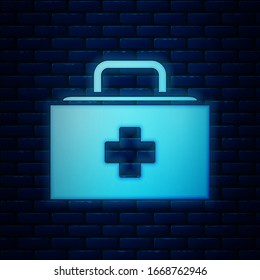 Leuchtendes Neon-Kit für Erste Hilfe Symbol einzeln auf Backsteinmauern Hintergrund. Medizinische Box mit Kreuz. Medizinische Ausrüstung für Notfälle. Konzept der Gesundheitsversorgung. Vektorillustration-Illustration