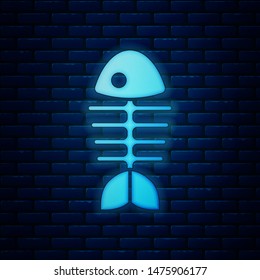 Glowing neon Fish skeleton icon isolated on brick wall background. Fish bone sign.  Vector Illustration