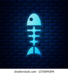 Glowing neon Fish skeleton icon isolated on brick wall background. Fish bone sign.  Vector Illustration